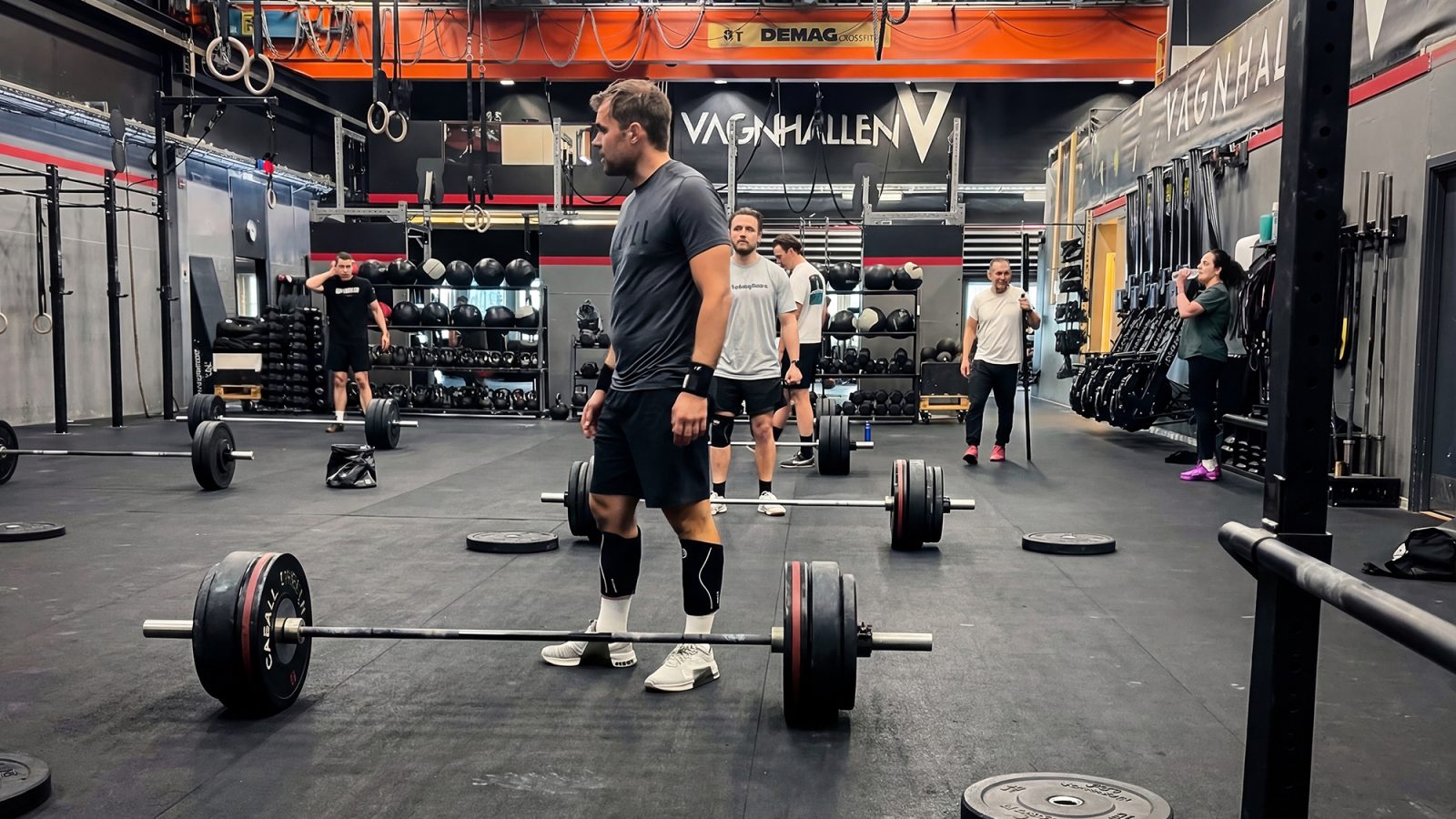 Jemand trainiert im Fitnessstudio „Vagnhallen“ in Göteborg, einer ehemaligen Straßenbahnhalle mit hoher Deckenhöhe, industriellen Details und freien Gewichten.